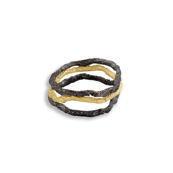 The November's Moon ring features a captivating combination of textures and materials. With its textured 18k yellow gold band paired alongside two blackened sterling silver elements, it creates a stunning contrast that intertwines harmoniously. The absence of a specific arrangement hints at a natural, organic feel, allowing each element to complement the other in an effortless manner.