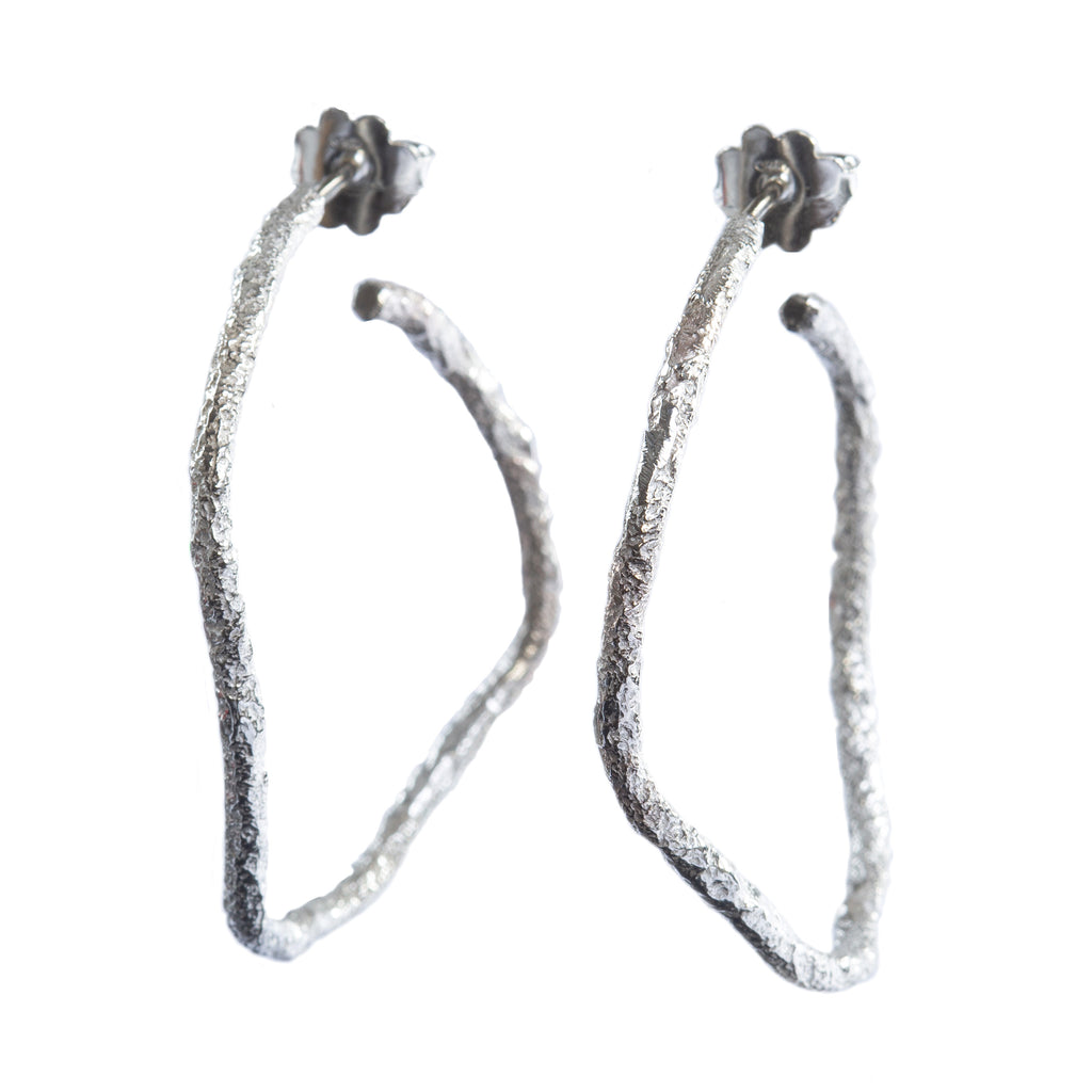 The Spark & Soul hoop earrings in sterling silver showcase simplicity with a touch of earthy and contemporary flair.  • Sterling silver  • Diameter: 1.5"