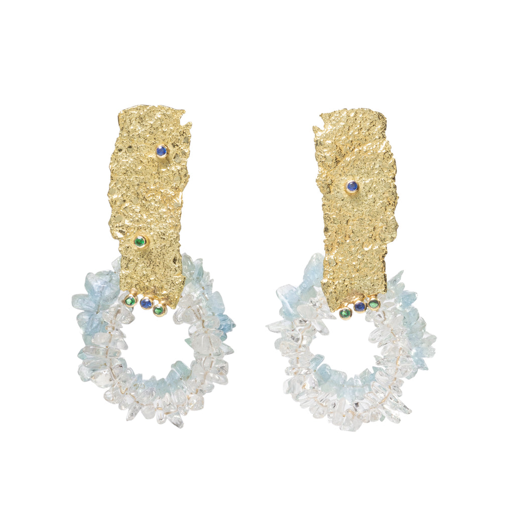 Good Vibes Circle with Colors Earrings by Emanuela Duca - Textured 18K yellow gold irregular elements showcasing two large circles, one adorned with aquamarine stones and the other with crystal rocks, and accented by small emeralds and sapphires. Radiating elegance and positivity, these earrings are the perfect accessory to add a touch of sparkle to any special ensemble. One of a kind. Heights: 2.45 inches. Posts & clips.