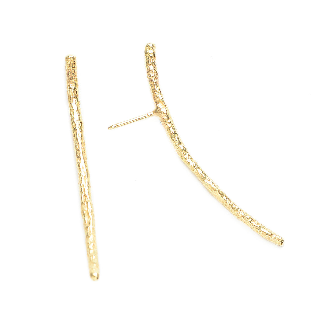 The Under a Tree earrings is a pair of elegantly designed accessories that exude simplicity and character. They feature a gently curved bar crafted from textured 18k yellow gold, capturing the essence of natural beauty with a refined touch. The minimalist design ensures versatility, making these earrings perfect for both everyday wear and special occasions.  • 18k yellow gold  • Length: 1.75"