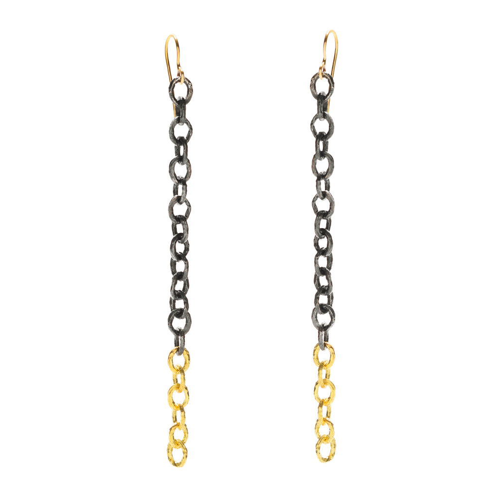 The Under a Tree earrings are designed to make a bold statement with a touch of edge and personality. These striking earrings feature a handmade chain of textured 18k yellow gold, beautifully contrasted by a chain crafted from blackened sterling silver. The fluid, elongated design creates a fashion-forward look that is both dynamic and sophisticated. Perfect for those who love to stand out, the Under a Tree earrings are a unique blend of elegance and modern style.  