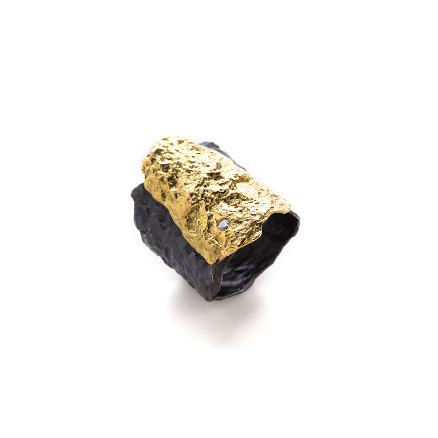 Roccia Blackened Silver & 18K Gold Ring by Emanuela Duca. Ragged surfaces of 18k yellow gold and blackened sterling silver in a fusion of past and present, where the timeless meets the contemporary, offering a small 2 mm white diamond.